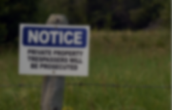 A faded image of a posted notice in a grassy area